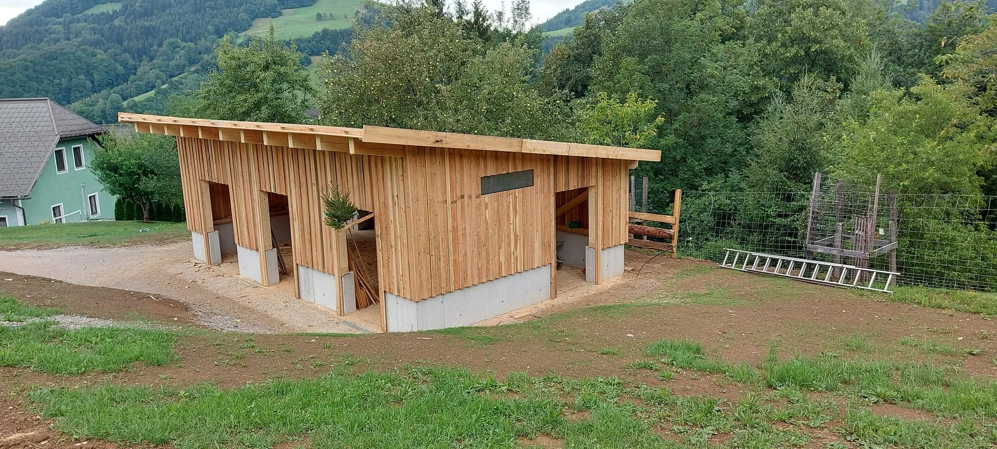 Der Hof von Rosenstein Alpakas: der selbst gebaute Stall mit Koppeln, eingebettet in die grünen Hügel des Mostviertels.